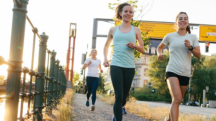 trois femmes en train de courir au bord d'une route