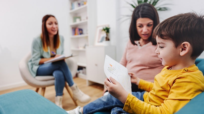 Illustration de la prévention en santé mentale : deux adultes et un enfant qui discutent autour d'un livre