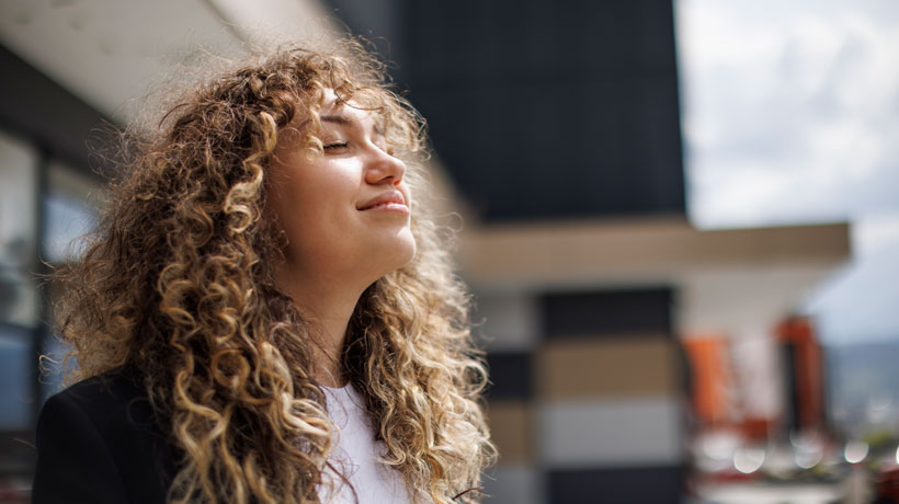 Une jeune femme qui respire à plein poumons dirigée vers l'avenir