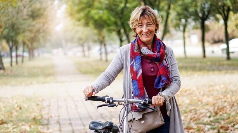 Une femme visiblement en forme et souriante fait du vélo